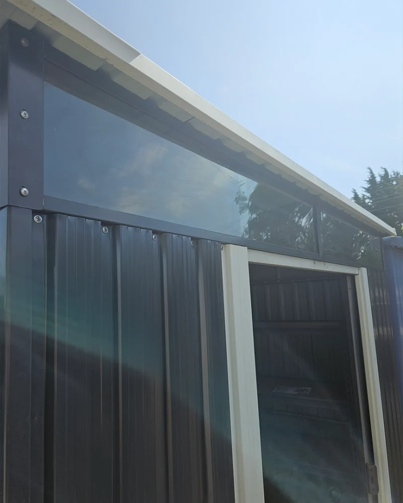 The full width window above the door of the shed