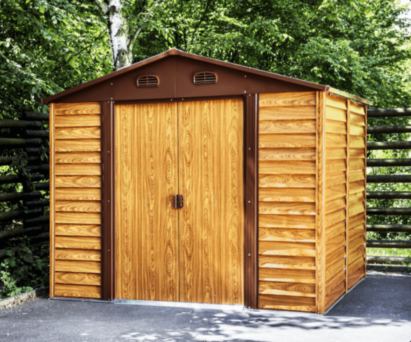 A woodgrain budget friendly shed sitting in a garden with trees behind it.