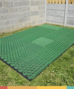 The Shed Base aka 'the eco base' from Sheds Direct Ireland. It's an army-green coloured mesh construction that is sitting on a grassy garden. There is a black membrane under it and there is a grey wall to either side of it.