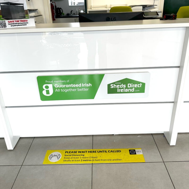 The sheds direct ireland showroom's front desk, adorned with a sign that reads 'proud members of Guaranteed Irish'