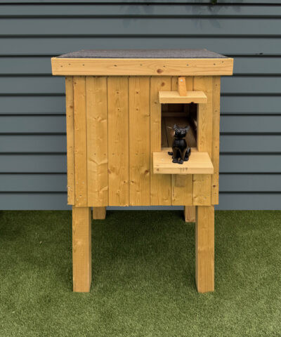 A single Cat Hut raise off the ground with a Cat ornament in the doorway