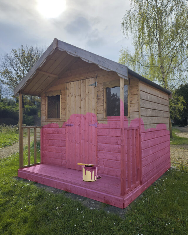 A shed that someone has begun to paint pink