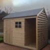 The Log Store in a garden with a yellow-blue sunset behind it