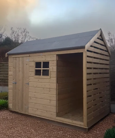 The Log Store in a garden with a yellow-blue sunset behind it