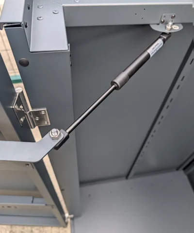 The gas hinge on the inside of the door on the outdoor storage box