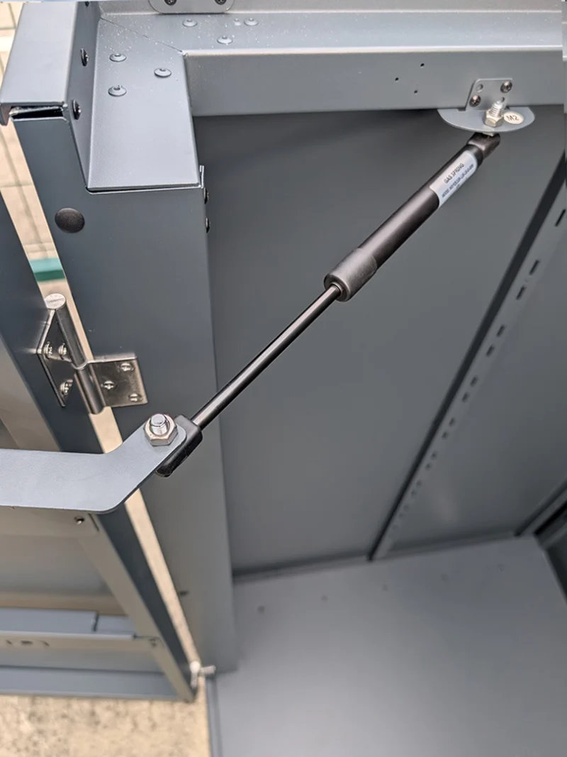 The gas hinge on the inside of the door on the outdoor storage box