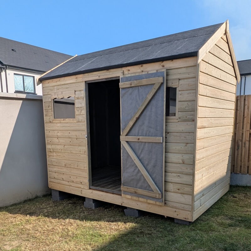 Wooden shed on uneven ground with blocks visible underneath