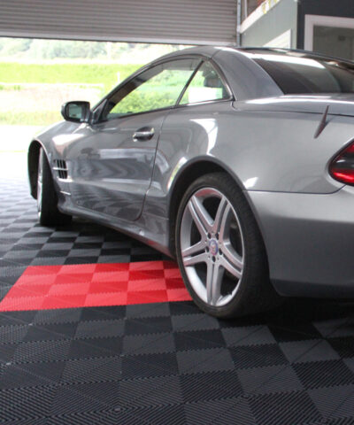 A large garage with the spaced delineated by red flooring