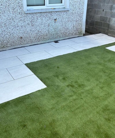 An Artifical grass lawn with laid paving slabs