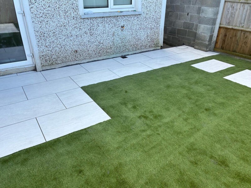 An Artifical grass lawn with laid paving slabs