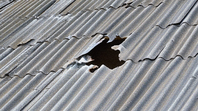 Hole in metal roof on wooden shed