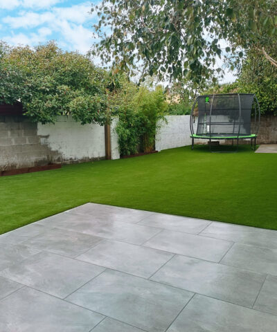 a garden with paving and synthetic grass