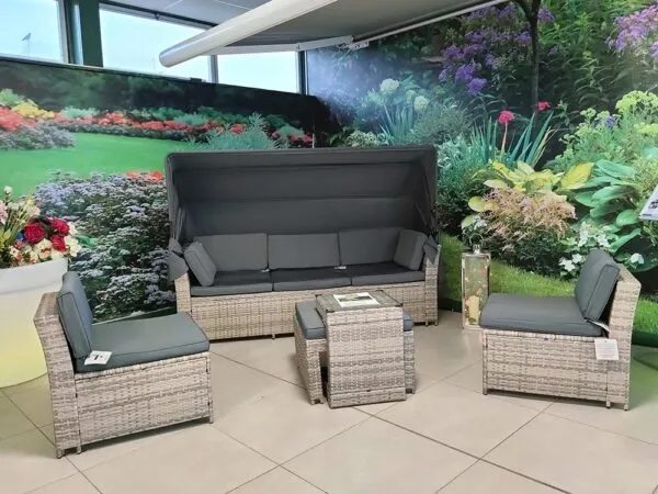 The 5 piece rattan sofa set in the sheds direct ireland showroom. It's in a corner up against a wall with a green and yellow floral design