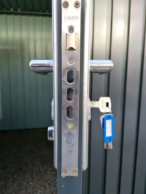 The side view of the inside of the locks on the premium panoramic sheds. There are three internal bolts visible, a hammer, two handles and a set of keys also